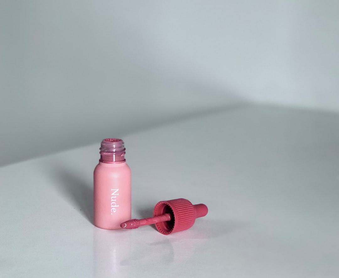 A pink bottle sitting on top of a white table