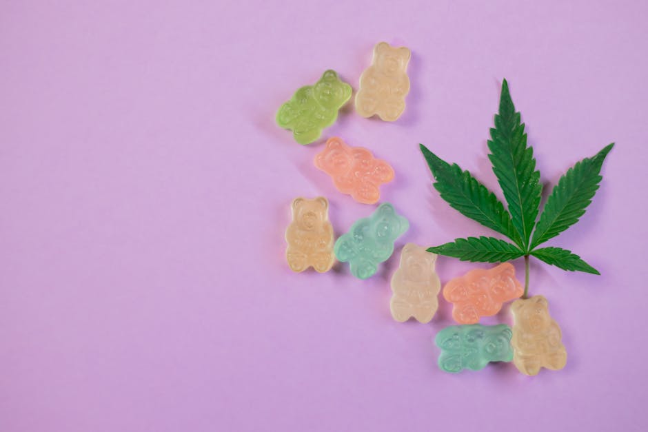Colorful gummy bears and a cannabis leaf on a pastel purple background, illustrating cannabis edibles.