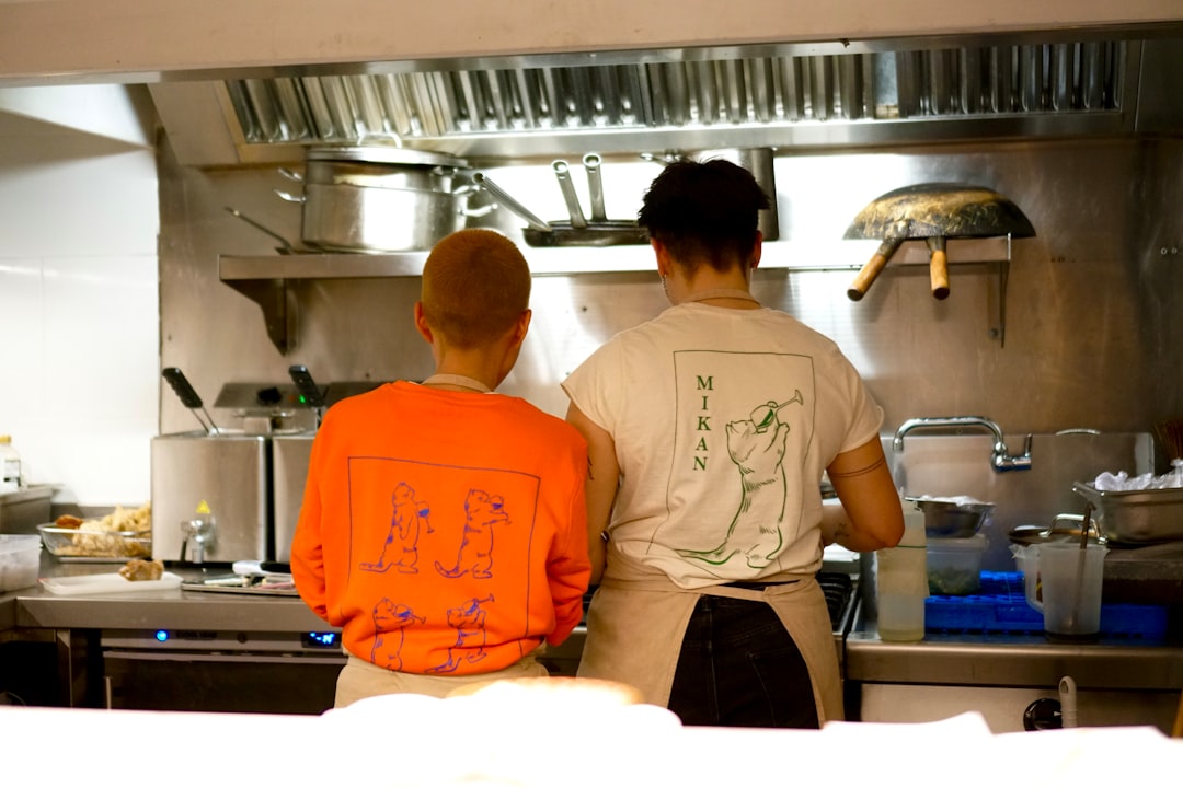 a couple of men standing in a kitchen next to each other