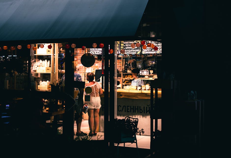 A vibrant night scene of a couple shopping inside a brightly lit store in Sochi, Russia.