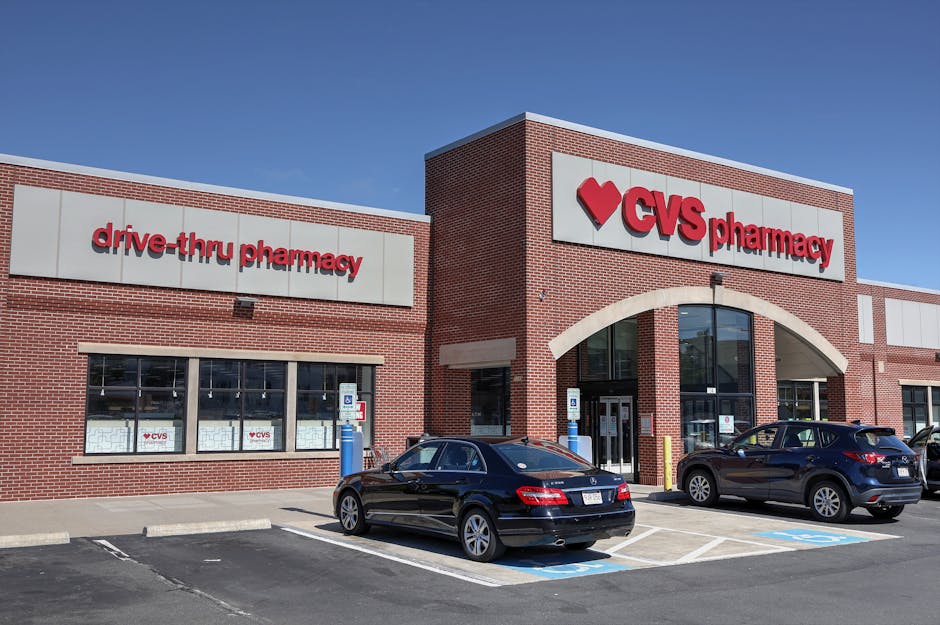 Brick CVS Pharmacy building with drive-thru, cars parked outside.