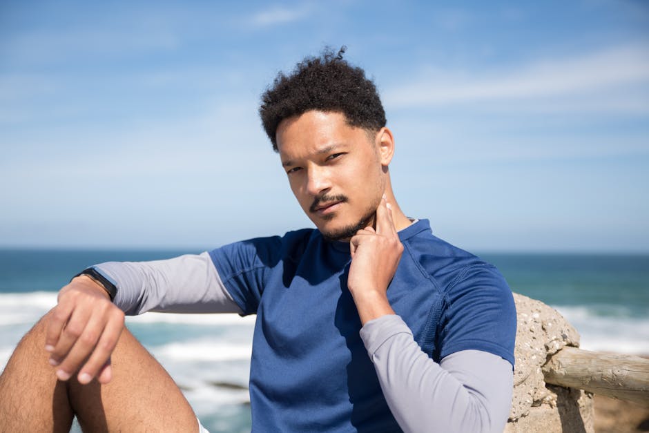 Man in blue shirt checking pulse with a scenic ocean background.